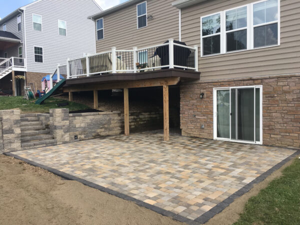 tri-color patio with varying pattern made from concrete paving stones. exterior dark gray border